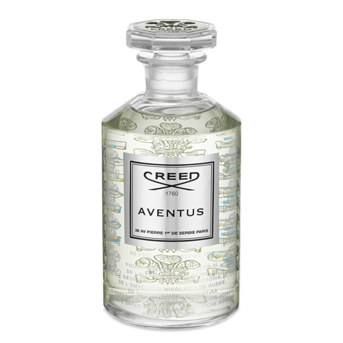 En klar glasflaska med en etikett som säger 'CREED AVENTUS' och innehåller en flytande parfym.
