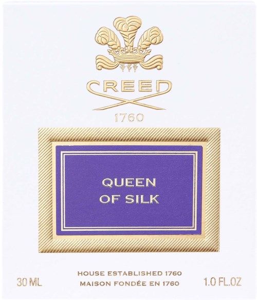 En parfymmärkning märkt 'Queen of Silk' med en vapensköld och gulddetaljer, som visar ett lyxigt märke.