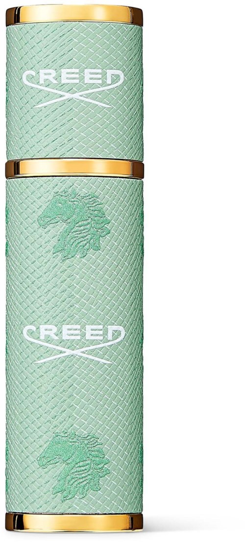 Kaksi tölkkiä vihreällä kuvioinnilla, kultaiset ylä- ja alareunat, ja logoja leijonasta ja sanasta CREED.