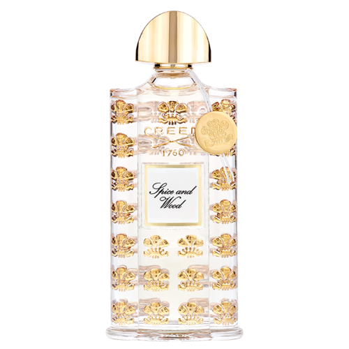 En klar parfume flaske med guldbi-design, en guldkapsel og en hvid label med teksten "Spice and Wood."