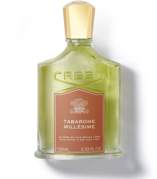 En grön parfyllare med ett guldkapsel och en rosa etikett som säger 'Tabarome Millese' av Creed.