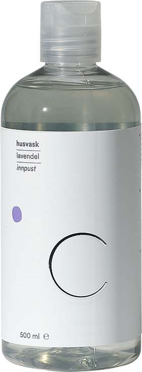 Selkeä pullo valkoisella etiketillä, pieni violetti piste ja suuri musta kirjain 'C'. Se sisältää nestemäistä saippuaa tai voidetta.