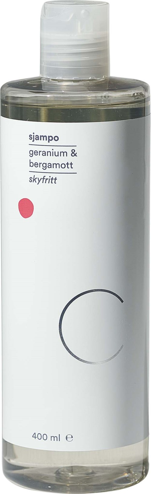 Clear flaske med hvit etikett, svart tekst som oppgir ingredienser, liten rosa prikke og en grå sirkel.