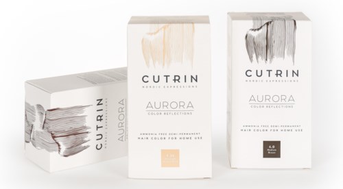 Förpackningar av hårfärg märkt Aurora, i beige och svart nyanser, med text och logga på vit förpackning.