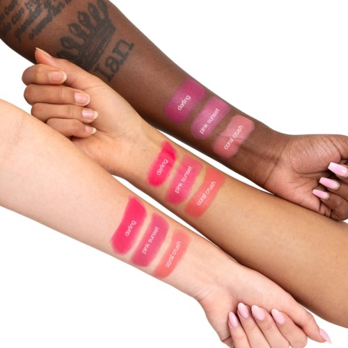 Drie mensen laten hun armen zien met getatoeëerde en beschilderde huid, met dezelfde lippenstiftkleuren genaamd 'Grapefruit', 'Pink Sugar' en 'Cocob Cream.'