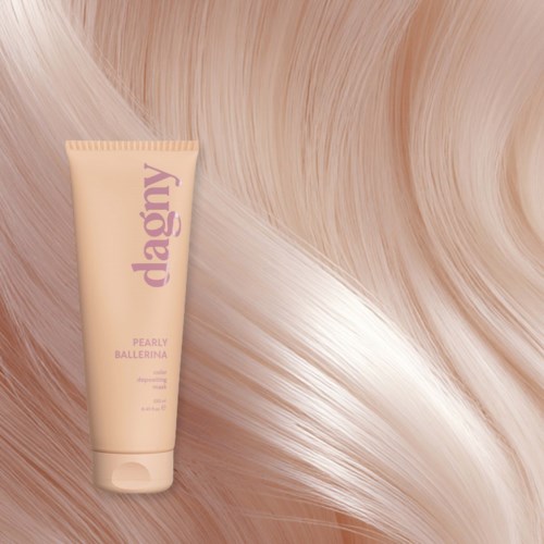 A tube of hair dye on a silky, shiny pink hair background.