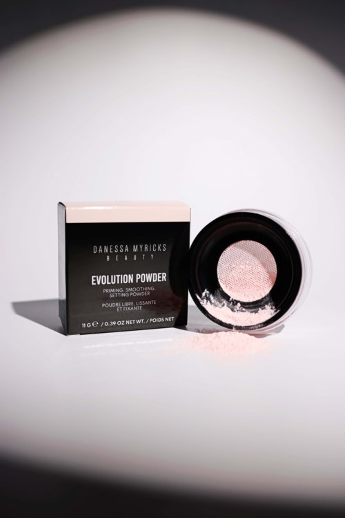 En svartvit låda märkt 'Evolution Powder' bredvid en rund behållare med rosa pulver.