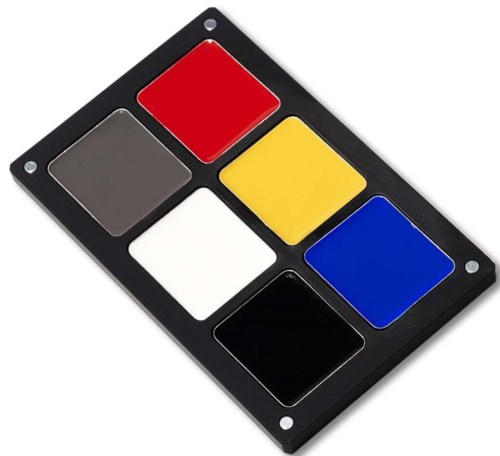 Een waterverfpalet met zes verschillende kleuren: rood, grijs, wit, geel, blauw en zwart. De palette is zwart met kleine gaten in de hoeken.