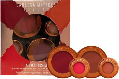 Läppbalsam i orange med olika nyanser, märkt 'Danessa Myricks Beauty,' på ett kortbakgrund.