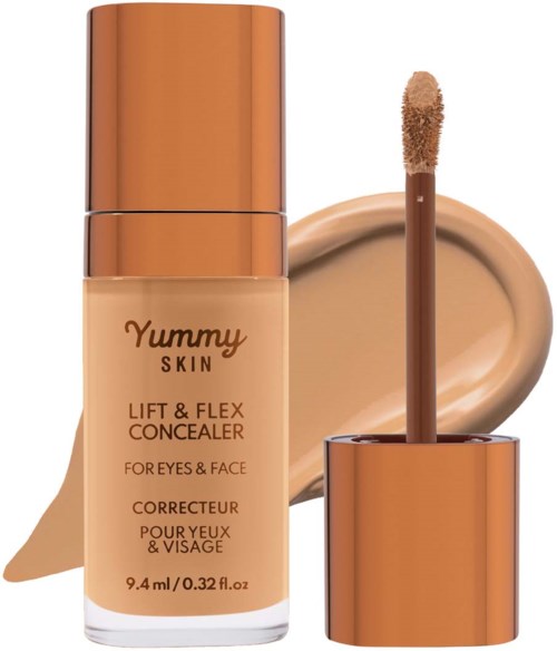 En flaske av Yummy Skin Lift & Flex Concealer med åpen applikator og en beige krem bak.