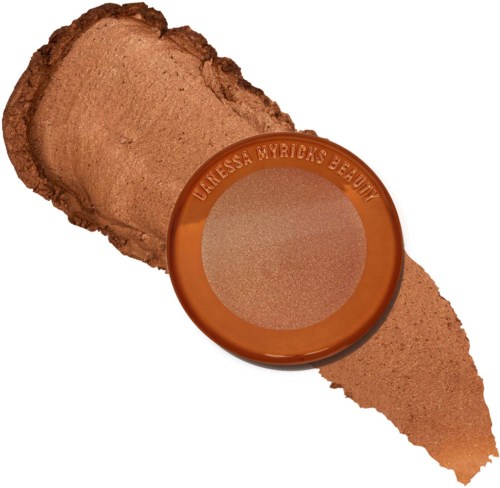 A brown pressed powder in a round container labeled 'Denessa Merrick's Beauty,' with some swatched on a white background.