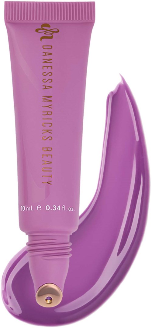 A pink tube with gold text that says Danielle Myricks Beauty, with purple cream swatched beside it.