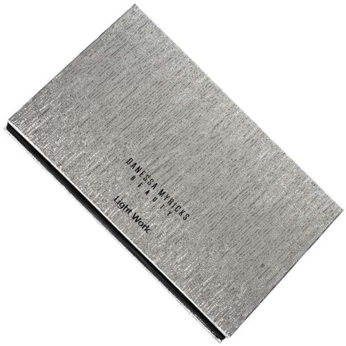 Ett silverfärgat, rektangulärt föremål med text på. Det verkar vara ett prov eller provbit av materialet Light Work.
