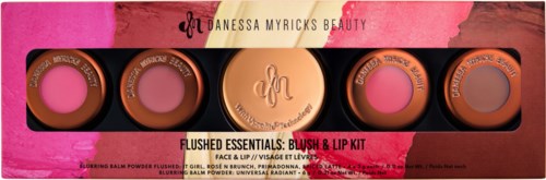 Fyra små behållare av blush och läppfärg, märkt som Flushed Essentials, med rosa och bruna nyanser, i en färgglad låda.