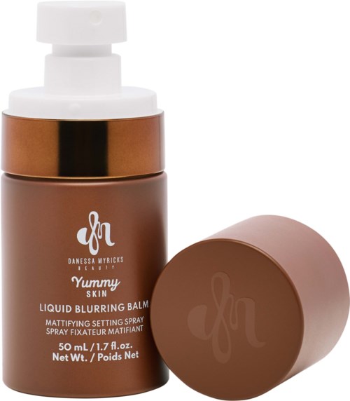 En brun flaska med vit pump och separat brun locket, märkt 'Yummy Skin' flytande skuggbalm.
