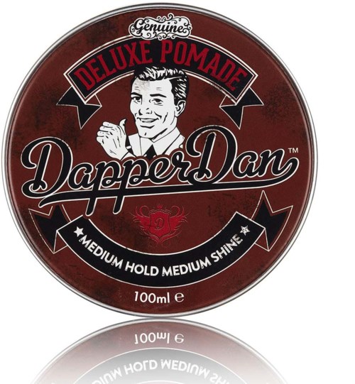 En rund, rød tinskrin med retrologo, glade mænd og tekst om pomade og styling.