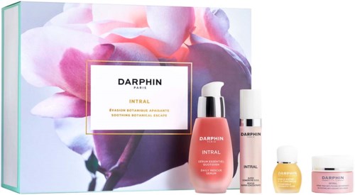 Een huidverzorgingsset met vier producten, roze en gele verpakkingen, en een bloemenachtergrond voor Darphin Intral.
