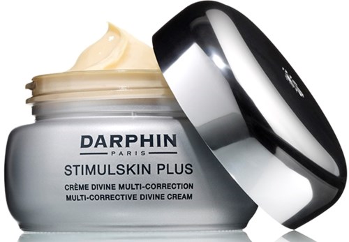 En burk Darphin Stimuluskin Plus multi-korrigerande gudomlig kräm med ett silvrigt lock, delvis öppet och visar krämen inuti.