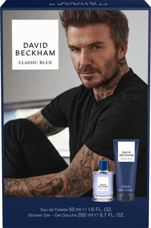David Beckham Classic Blue parfumeæske med en tatoveret mand ved siden af matchende shower gel og duftflaske.