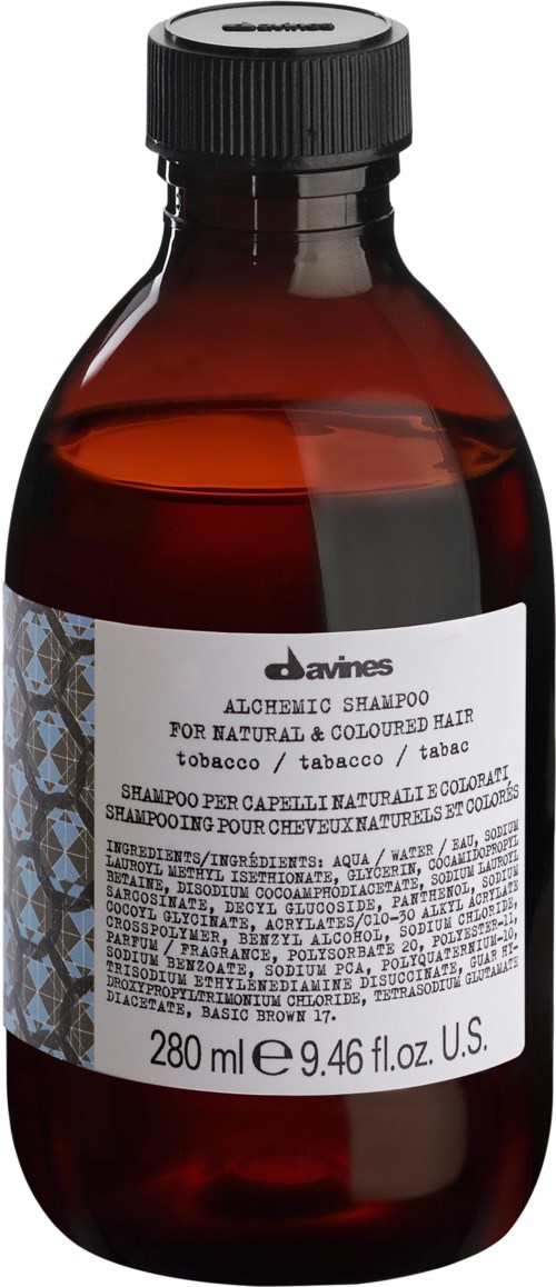 A brown bottle with a white label, black cap, and text about aloe and tobacco for hair.