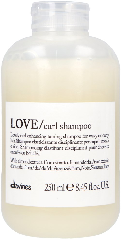 En vit flaska med en etikett som visar att det är Love/Curl Shampoo, 250 ml, med mandelutdrag, för lockigt hår.