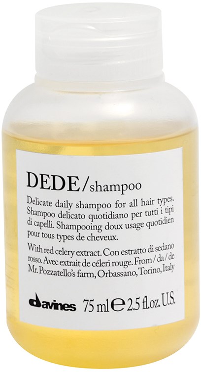 En gul shampoo-flaske med hvid etiket, sort tekst og hvid hætte.