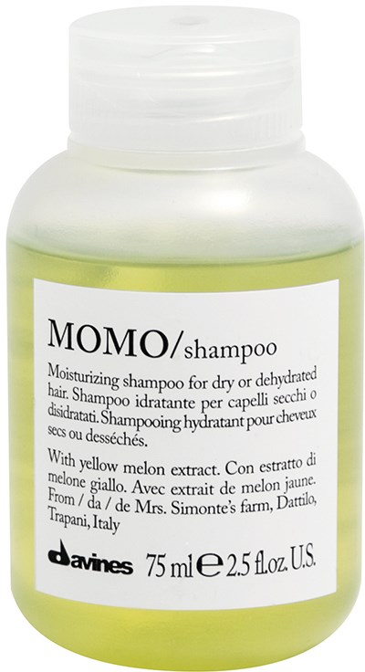 Hvid flaske med Momo shampoo med gulgrøn væske og en etiket der beskriver, at den indeholder melonekstrakt.