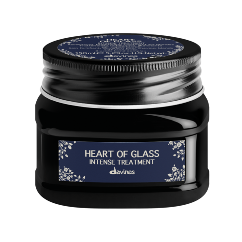 A black jar with a blue label that says 'Heart of Glass Intense Treatment' by Davines, decorated with white floral designs.