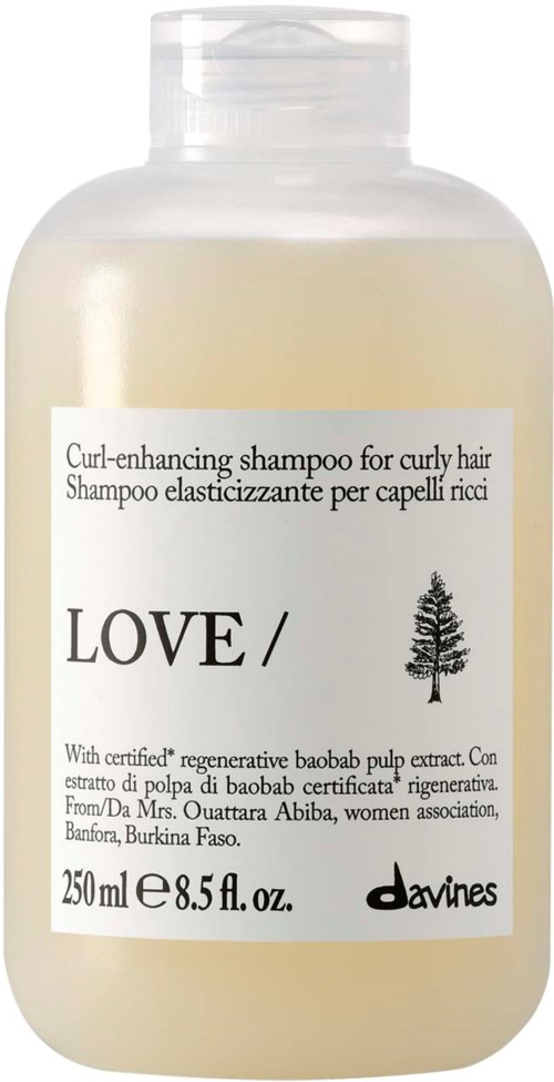 En beige flaska med Davines Love lockförbättrande schampo, vit kork och etikett med produktinformation.