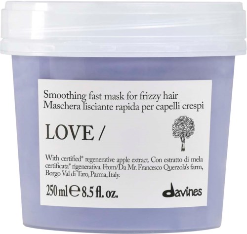 En lila behållare av Davines Love utjämningsmask för frissigt hår, med vit lock och produktetikett som visar detaljer.
