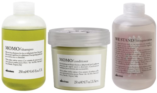 Tre hårvårdsprodukter: schampo, balsam och en rosa flaska med etiketten 'We Stand' för återhämtning.