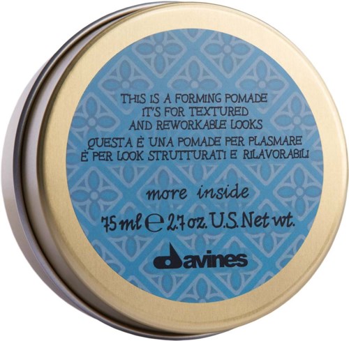En rund behållare med en blå och beige etikett. Text beskriver den som en texturerad, omarbetbar stylingpomada från Davines.