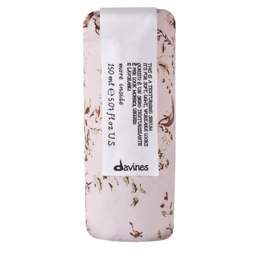 A small, pink item with brown and white floral pattern and a white label with black text.