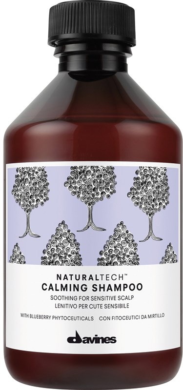En brun flaske med Davines Naturaltech Calming Shampoo med etiket, der viser træer og tekst.