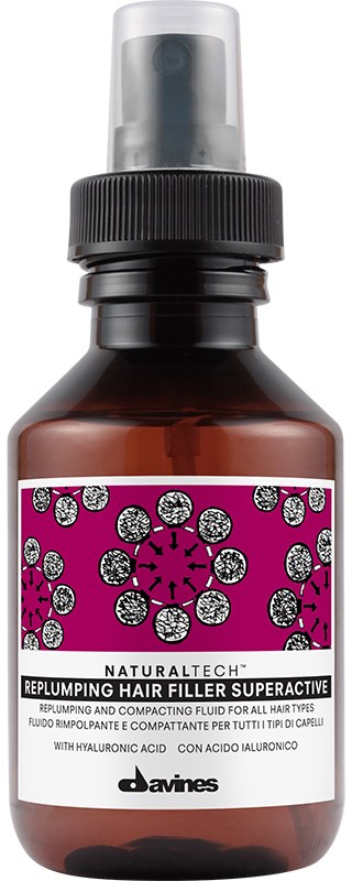 En lille brun flaske med sort sprayhætte, mærket til hårpleje med pink og lilla design og tekst.
