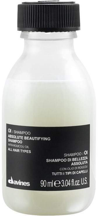 En lille hvid flaske med sort låg mærket 'shampoo' til alle hårtyper med naturlig olie.