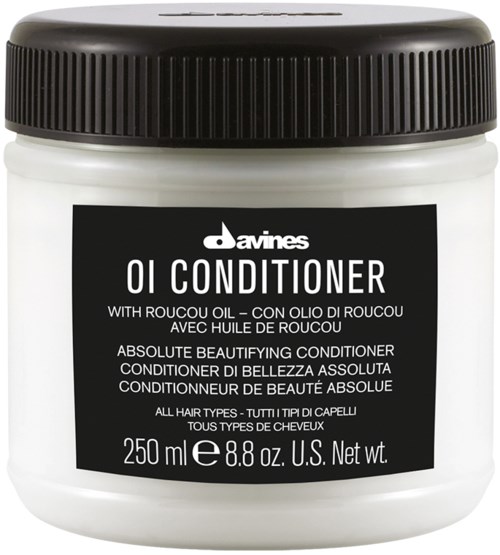 En hvid beholder med sort låg, mærket som Davines OI Conditioner, med oplysninger om ingredienser og størrelse.
