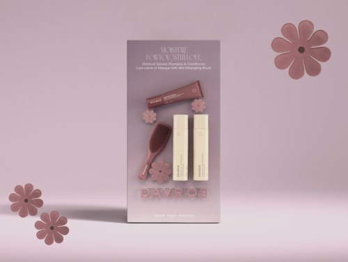 Et hudplejesæt med to flasker, en børste og pink blomsterdekorationer på lyserødt baggrund.