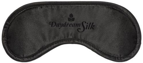 En svart sovmask med orden 'Daydream Silk' tryckt på den, utformad för att täcka ögonen för sömn.