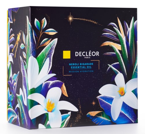 Dekorativ emballage til Decléor Neroli Bigarade Essential Oil med blomsterdesign og stjernehimmel baggrund.