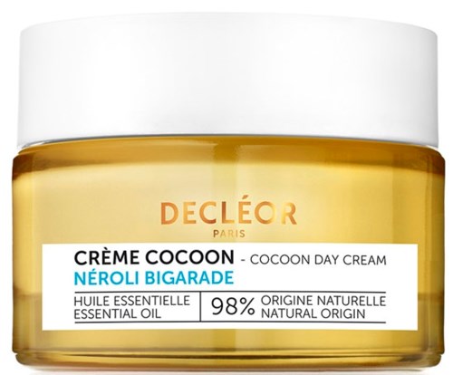 A round, yellow jar with a white lid containing Decleor Cocoon Neroli Bigarade day cream, mostly text on the label.