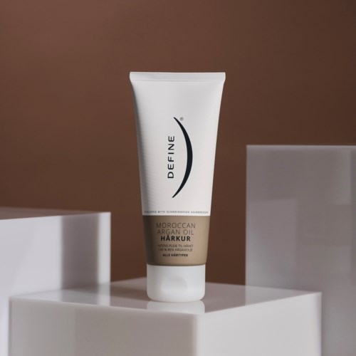 En hvit tube merket 'Define' med 'Moroccan Argan Oil Harkur' på en hvit overflate.