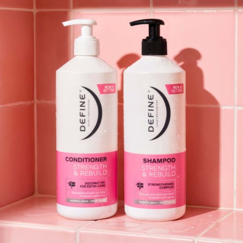 To flasker med hårplejeprodukter, konditioner og shampoo, med pink og hvide etiketter på en lyserød flisehylde.
