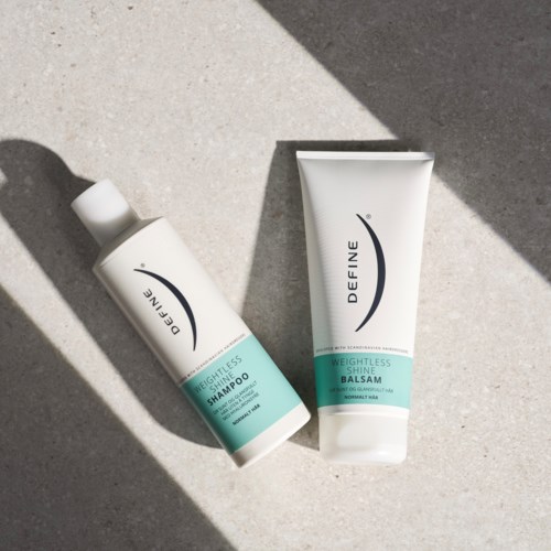 To hårpleieprodukter: sjampo og balsam, begge merket 'Weightless' fra merket Define, på en lys betongoverflate.