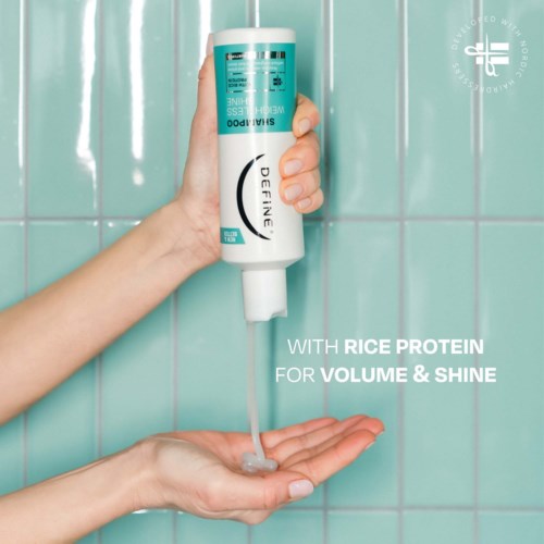 A bottle of hair product being squeezed onto hands with a tiled wall background. It promotes rice protein for volume and shine.