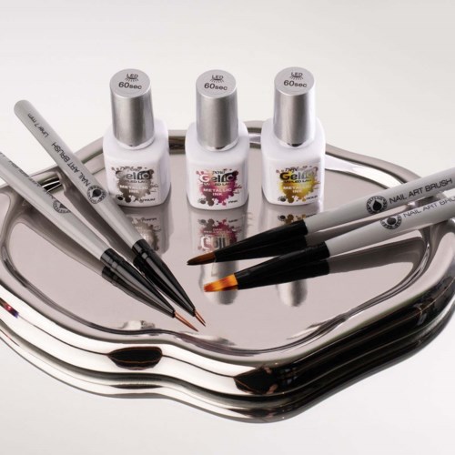 Nail gel bottles with brushes on a shiny tray, ready for manicure. Nail brushes and bottles are used for nail art.