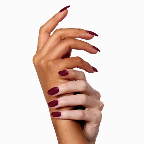 Two hands with manicured nails intertwined, one hand on top, against a white background.