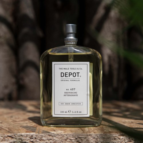 Een heldere glazen fles met een zilveren dop en een wit label, buiten op hout geplaatst, bevat aftershave.