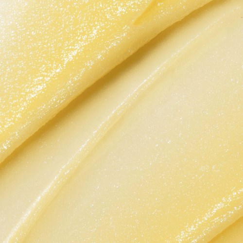 Zbliżenie na gładkie, jasnożółte plasterki sera z błyszczącą powierzchnią i zakrzywionymi krawędziami.