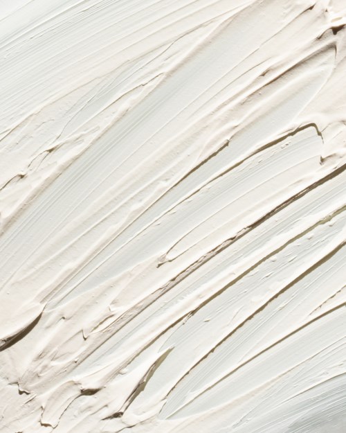 Creamy white textured surface with visible brush strokes and lines.